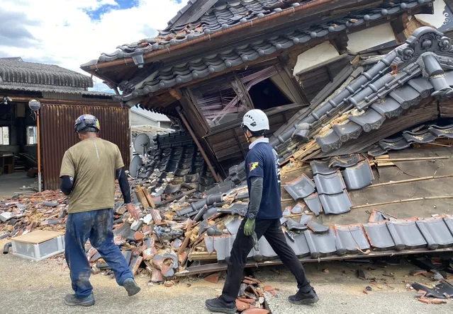 倒壊した家屋の前で状況を確認する支援メンバー